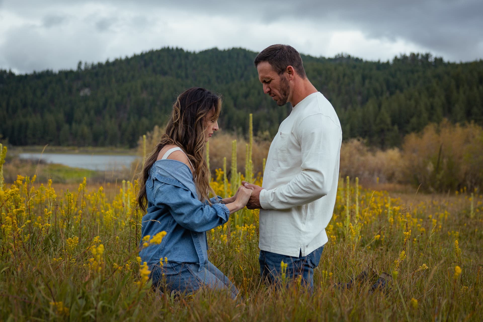Couple holding hands in a Lake Tahoe mountain meadow of yellow wildflowers
